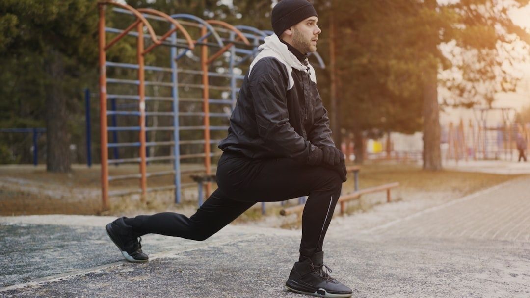 Person i träningskläder gör ett utfallssteg utomhus