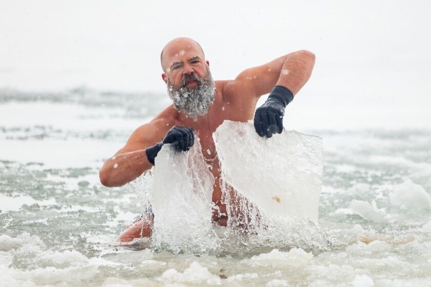Skäggig man bryter is i havet under ett kallt vinterbad